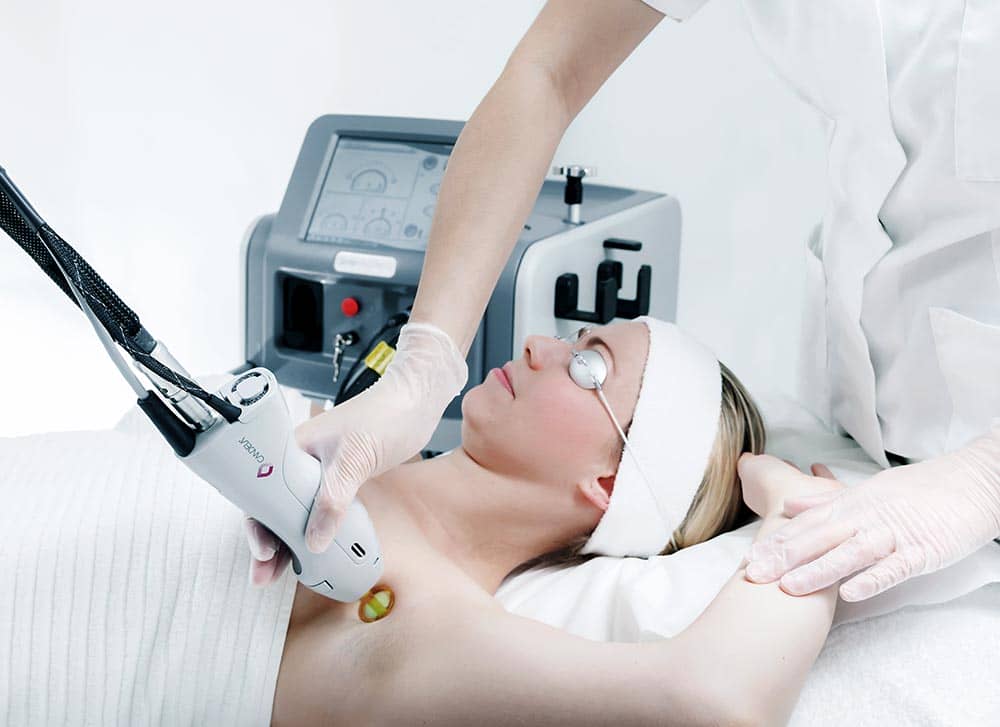 A woman receiving laser hair removal treatment on her underarm.