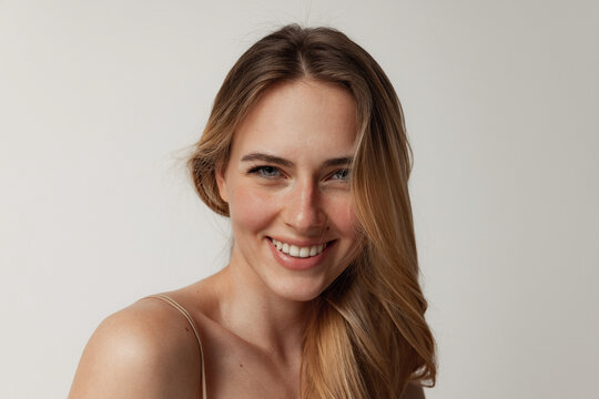 portrait of tender young woman with perfect face smiling at camera